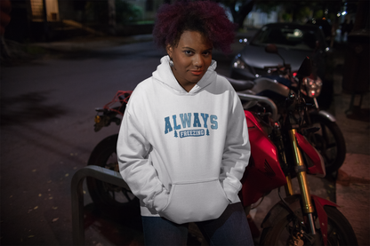 Young woman with curly hair wearing a white hoodie that says "Always Freezing," standing confidently in front of a red motorcycle at night. The hoodie pops against the dark background, making a statement for those who are always cold, no matter the season.