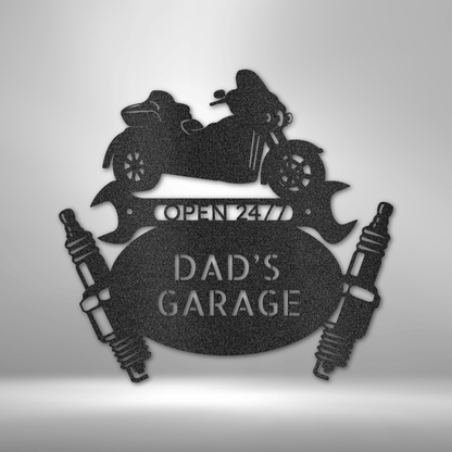 Steel sign featuring a motorcycle, wrenches, and spark plugs with 'Dadâ€™s Garage' text, a great gift for gearhead dads. Available in black, silver, white, bronze, and copper finishes.