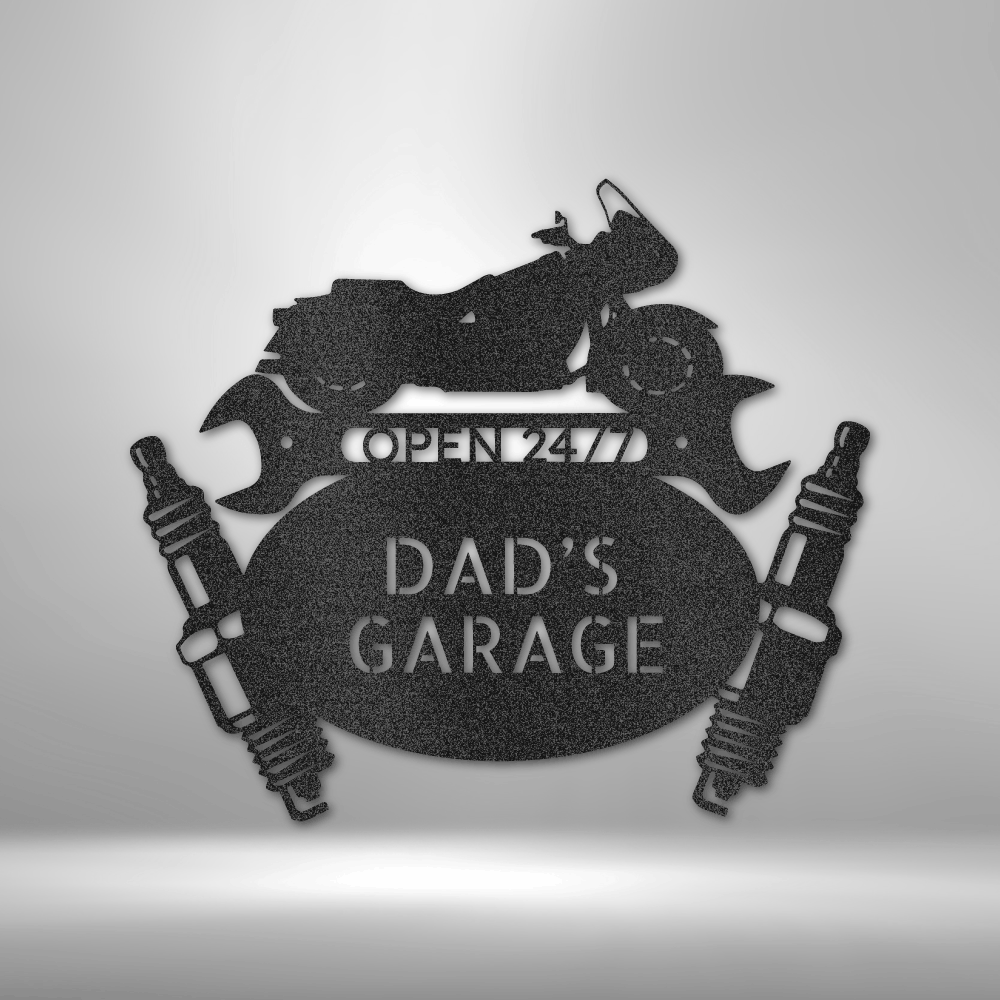 Dad’s Garage Steel Sign featuring a touring motorcycle silhouette atop two wrenches, an oval nameplate, and spark plugs on each side. Precision-cut from 16-gauge steel, powder-coated for durability, and available in Black, Silver, White, Copper, and Bronze finishes.