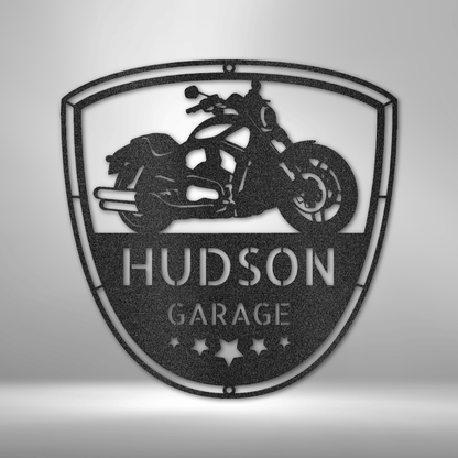 Custom Motorcycle Garage Steel Sign featuring a cruiser-style motorcycle silhouette inside a shield emblem, personalized with your name or garage title. Made from 16-gauge steel, powder-coated for durability, and available in Black, Silver, White, Copper, and Bronze finishes.